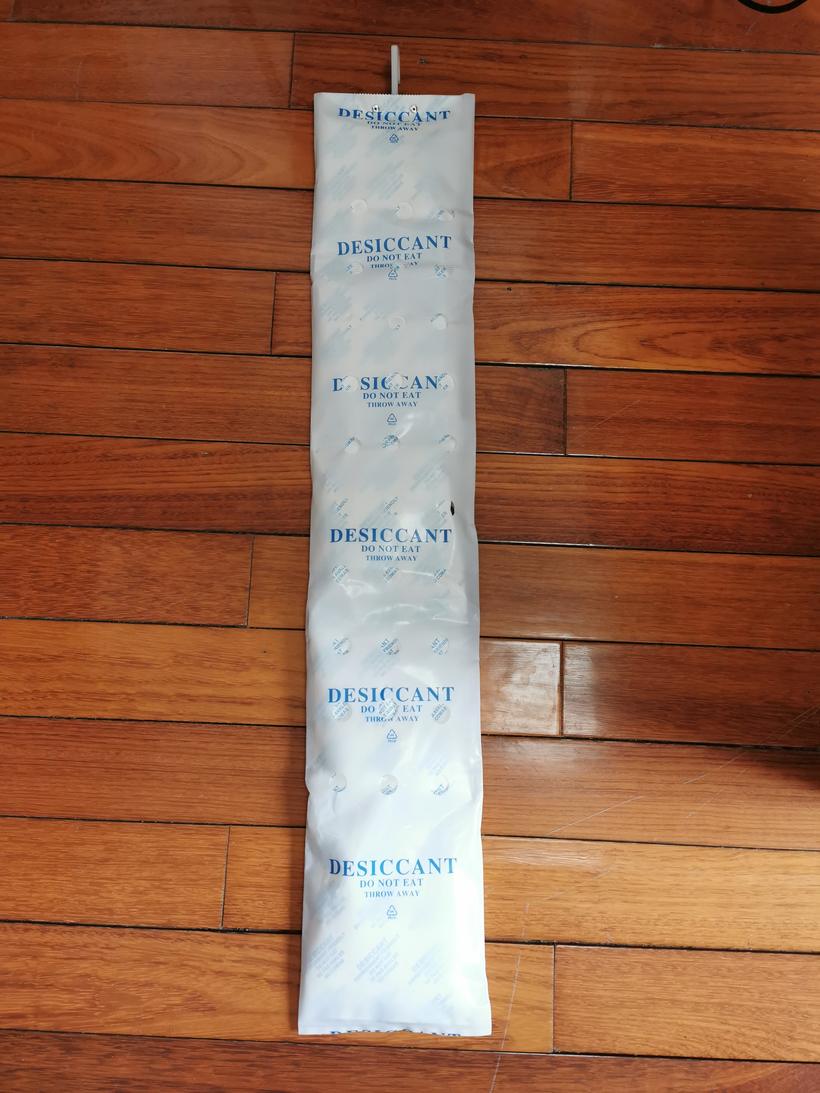 Multi-section strip container desiccant laid out in a continuous run on a wooden floor